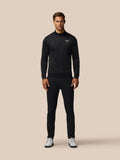 Man wearing black Golf Club Classic 1/4 Zip Debossed Top with subtle all over print against a beige backdrop