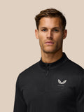 Male model wearing a black Golf Club Classic quarter zip top with a subtle embossed pattern and a white Castore wing logo on the chest