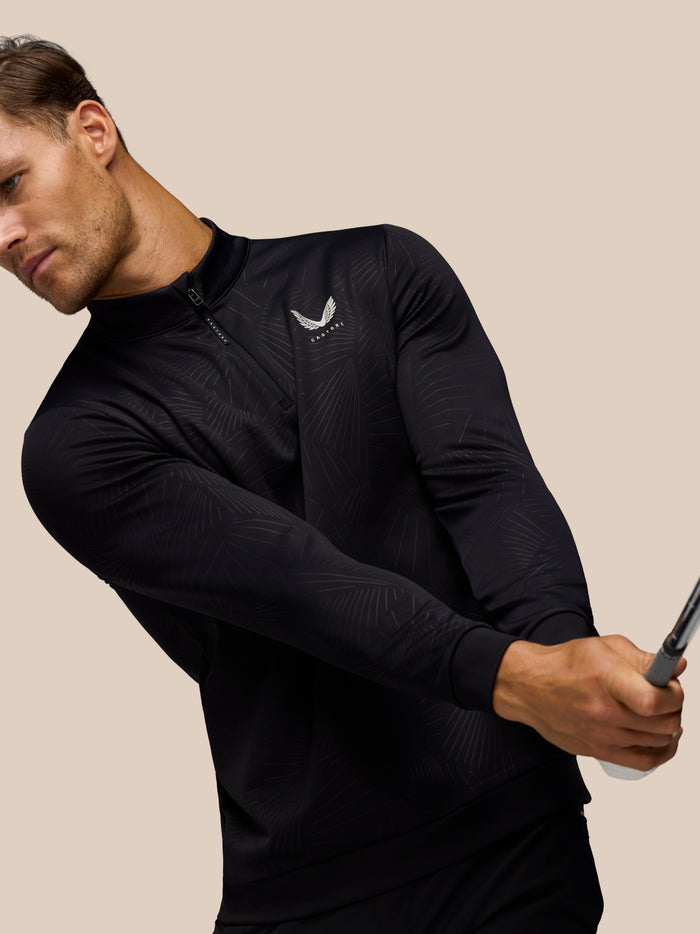 Side profile of man in black Golf Club Classic 1/4 Zip Debossed Top showing the zip detail and printed pattern
