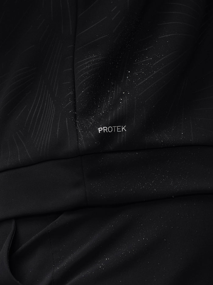 Close-up of black textured golf top fabric with water droplets and the PROTEK logo.