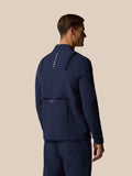 Back view of male model in midnight navy LVS winter jacket showing vertical Castore logo down the back