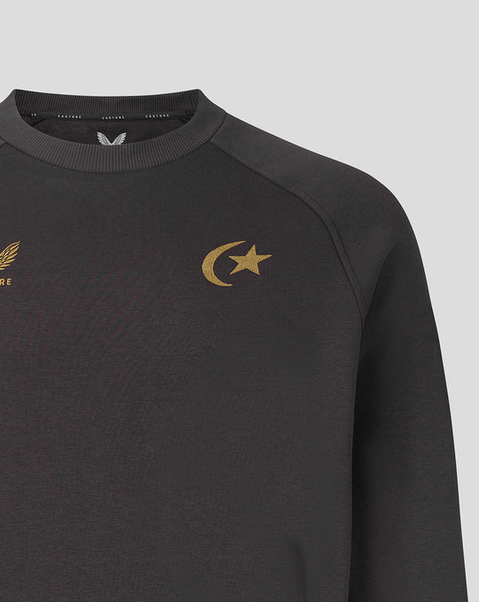 Close-up of dark grey sweatshirt chest with gold crescent and star emblem.