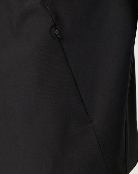 Close-up of black jacket showing angled side seam and concealed zip pocket