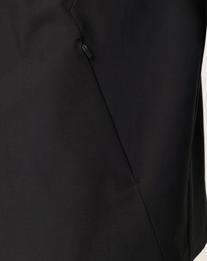 Close-up of black jacket showing angled side seam and concealed zip pocket