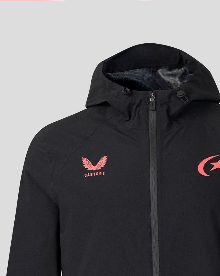 Close-up of black training jacket featuring pink Castore crest on left chest and pink crescent star on right chest with center zipper