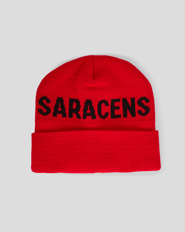 Close up of a red knit beanie with a black wordmark across the front