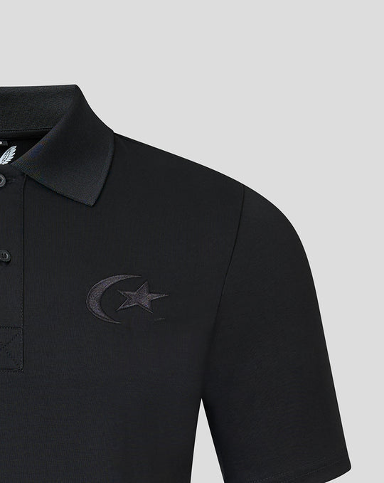 Left chest close up of black polo with crescent and star embroidery and collar visible