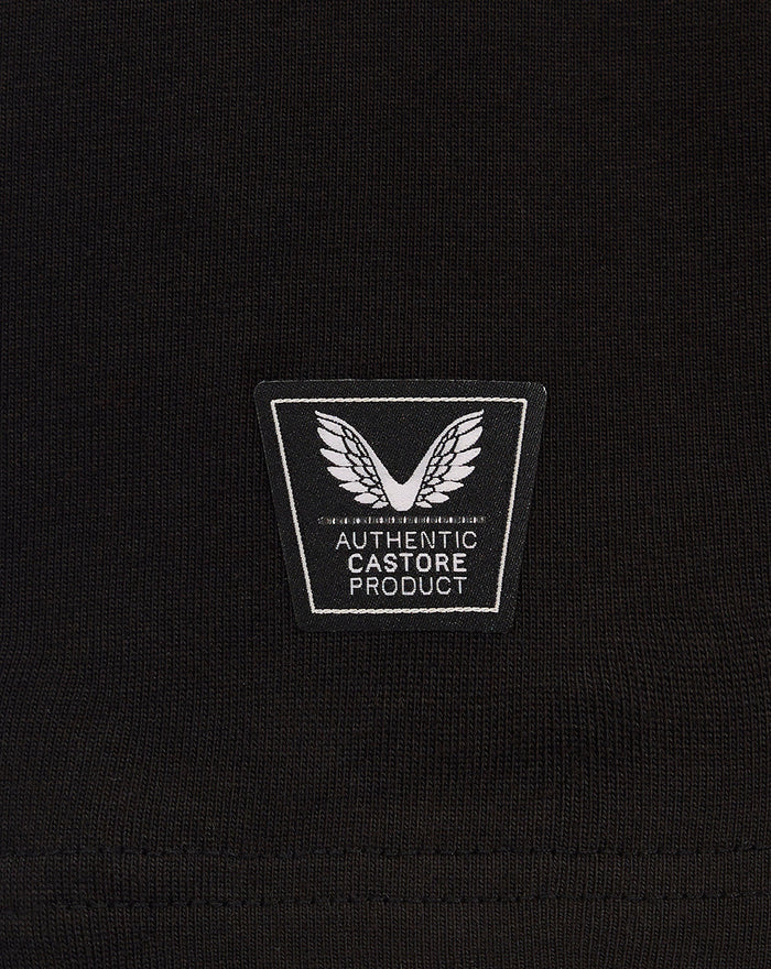 Close-up of black knit fabric with a square patch reading AUTHENTIC CASTORE PRODUCT and winged emblem.