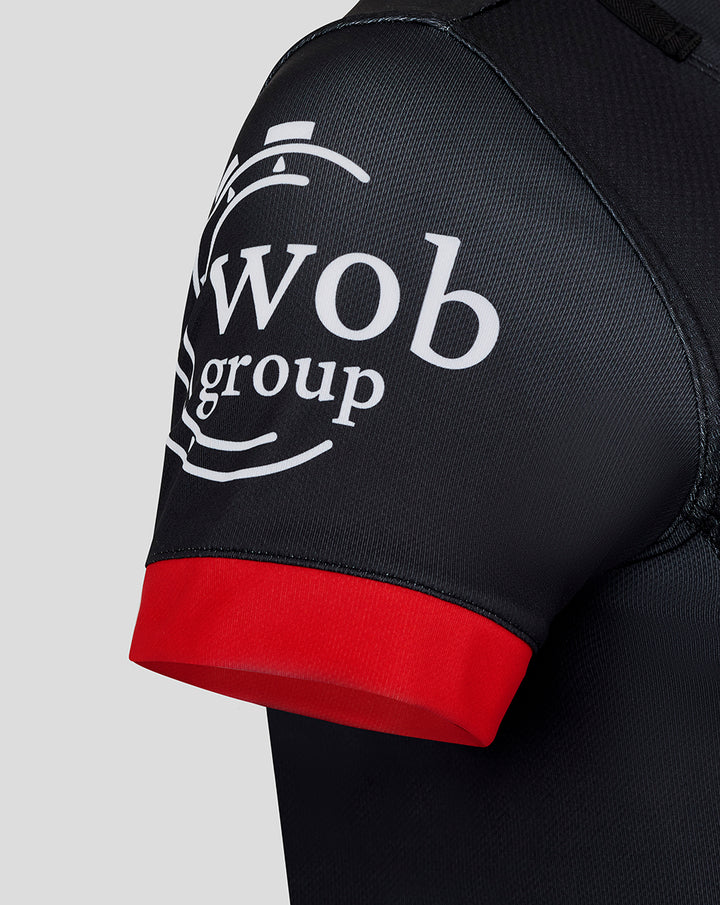 Sleeve detail with Wob group logo on black fabric and a bright red cuff.