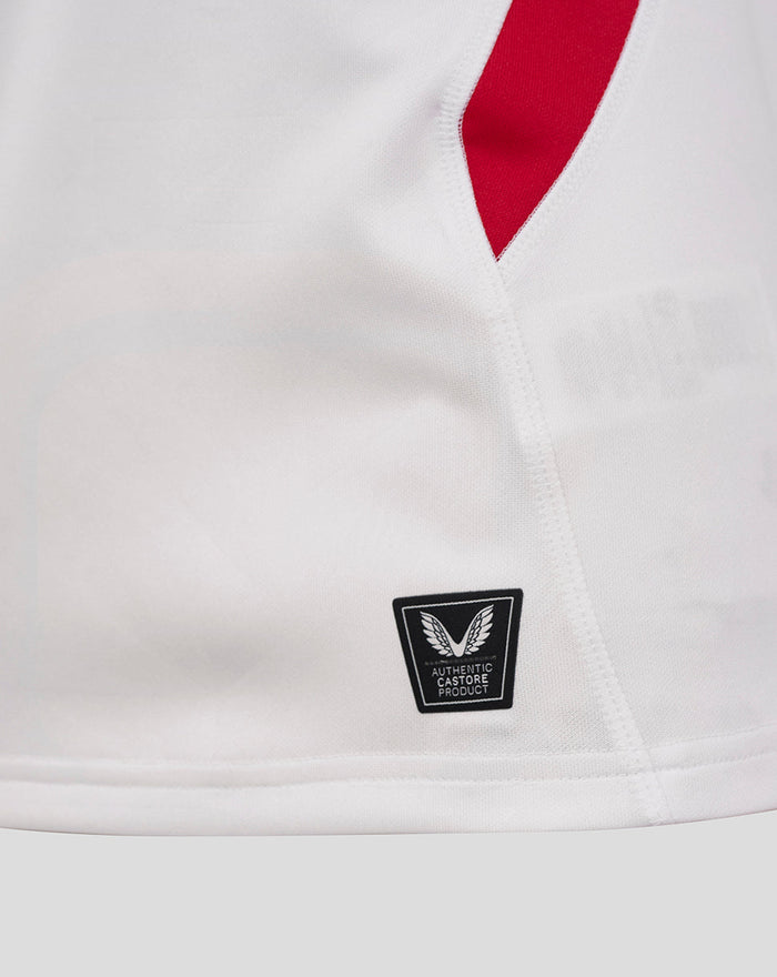 Close-up of white England rugby shirt with red side panel and authentic Castore product badge near the hem
