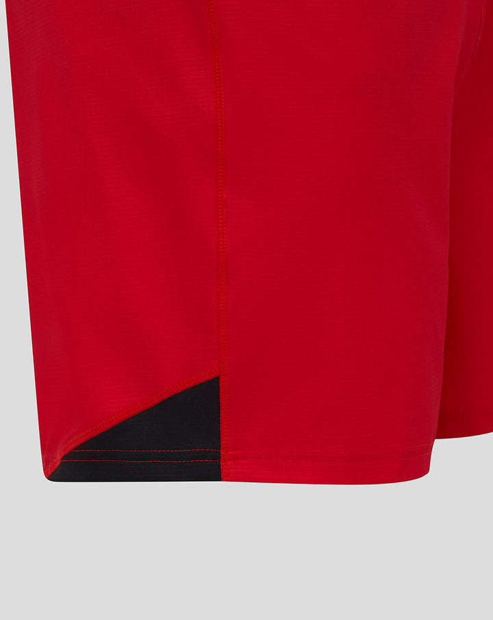 Close up of red Saracens Pro Home rugby shorts hem with a black underlay panel