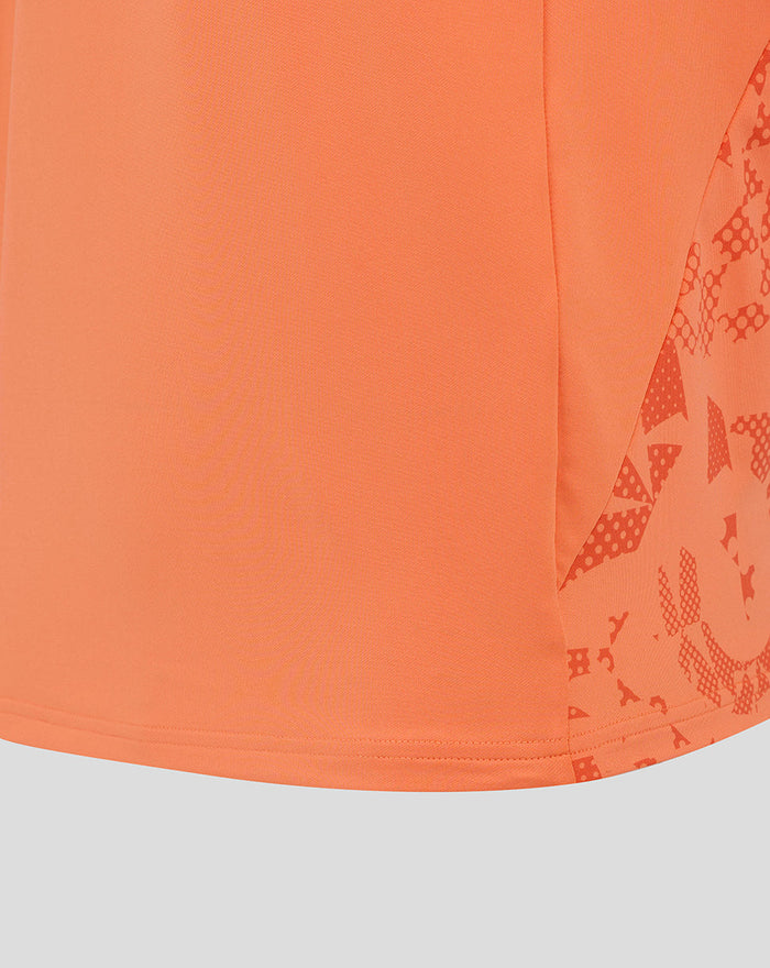 Close up of the orange Melon midlayer hem with a patterned side panel from the England Rugby top