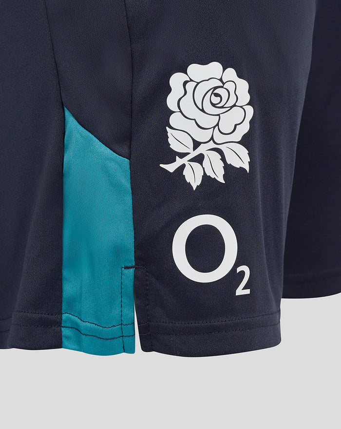 Close up of navy shorts showing a white rose crest and O2 logo on the right thigh with teal side panel