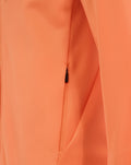 Close-up of melon orange fabric featuring a center front zipper and seam details on a rugby hoodie