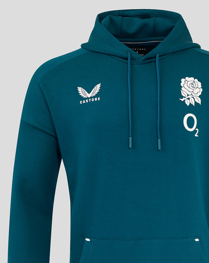 Close up of teal hoodie chest shows Castore logo on left and a white rose with O2 on the right.