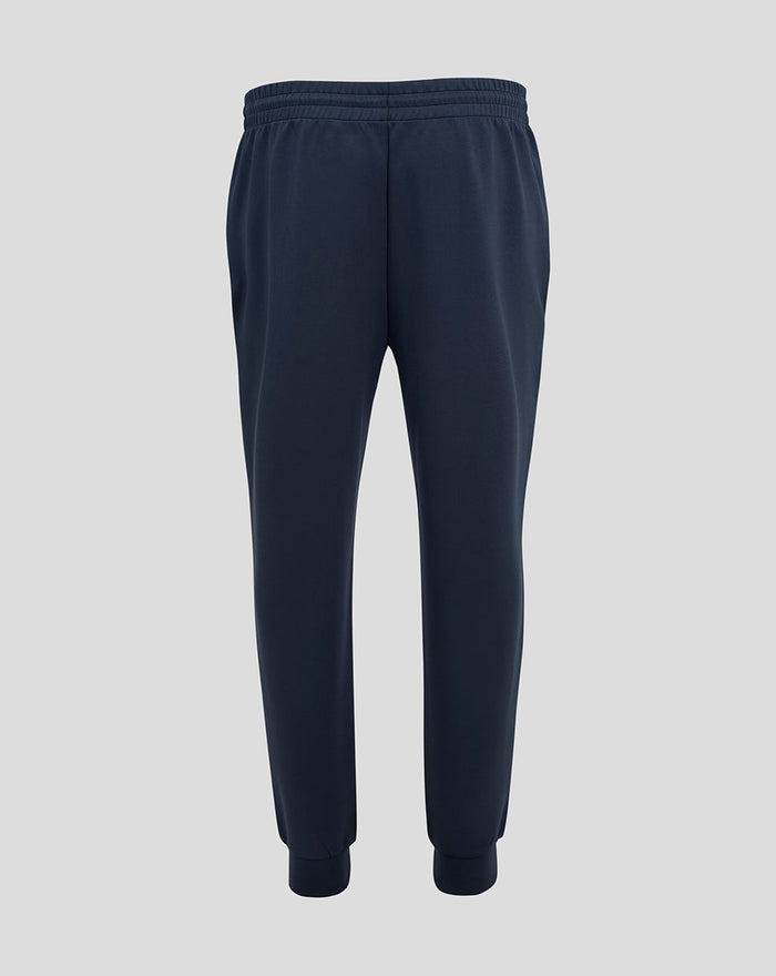 Back view of navy Travel Knit Pant showing logos on the thighs and ribbed cuffs