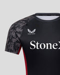 Front close up of Saracens jersey showing Castore logo and StoneX sponsor text on dark fabric with patterned sleeves