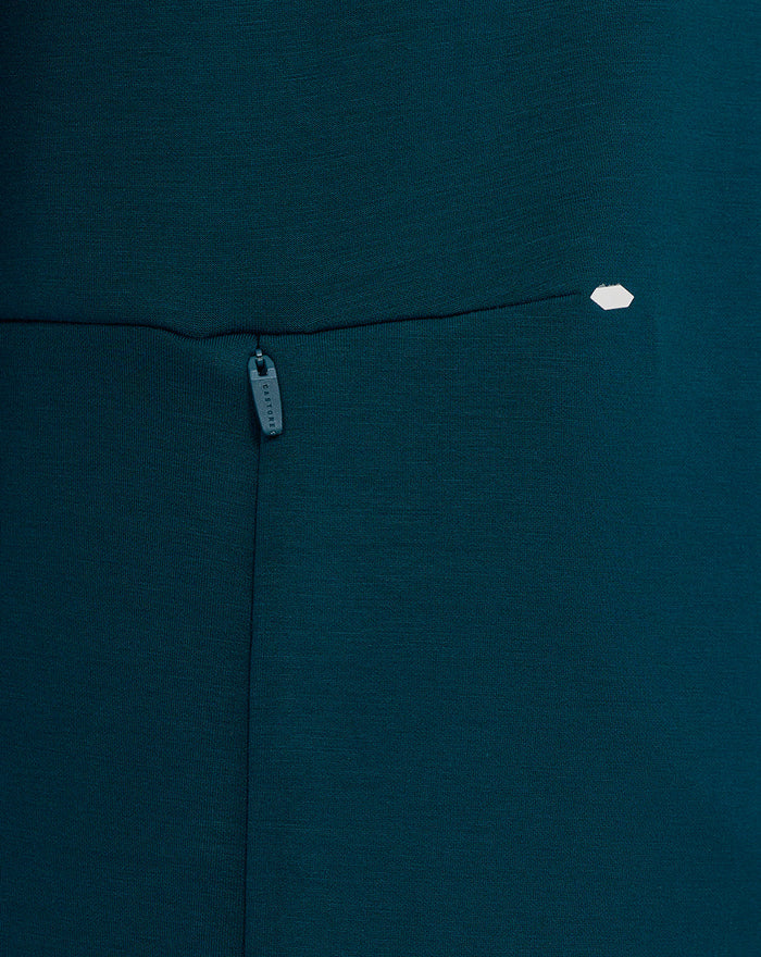 Close-up of teal Travel Crew Sweatshirt showing concealed zip pocket and Castore branding on the pull