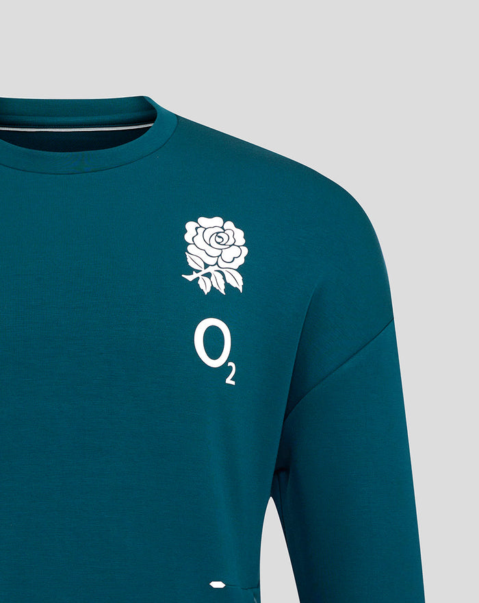 Close-up of teal Travel Crew Sweatshirt front left chest with white rose O2 branding