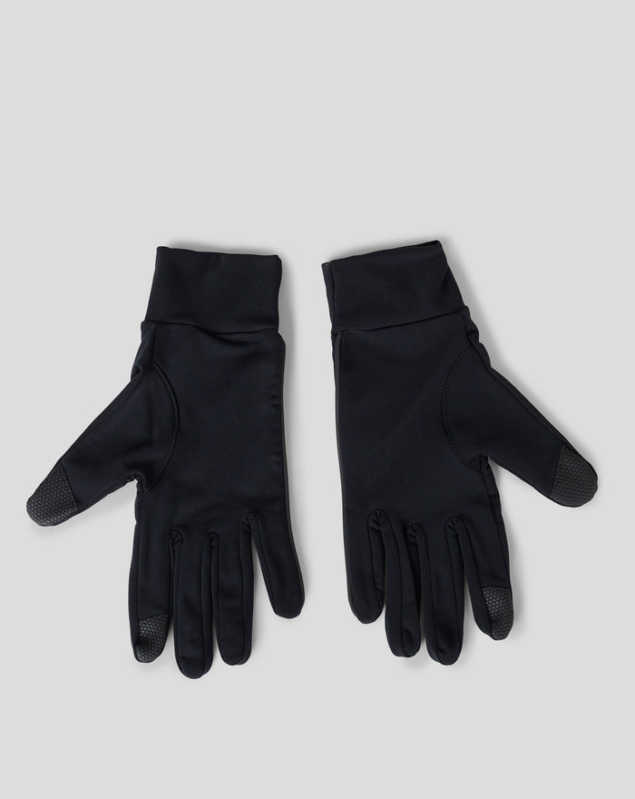 Close-up of black gloves showing textured palms and the Castore wing logo on the cuff